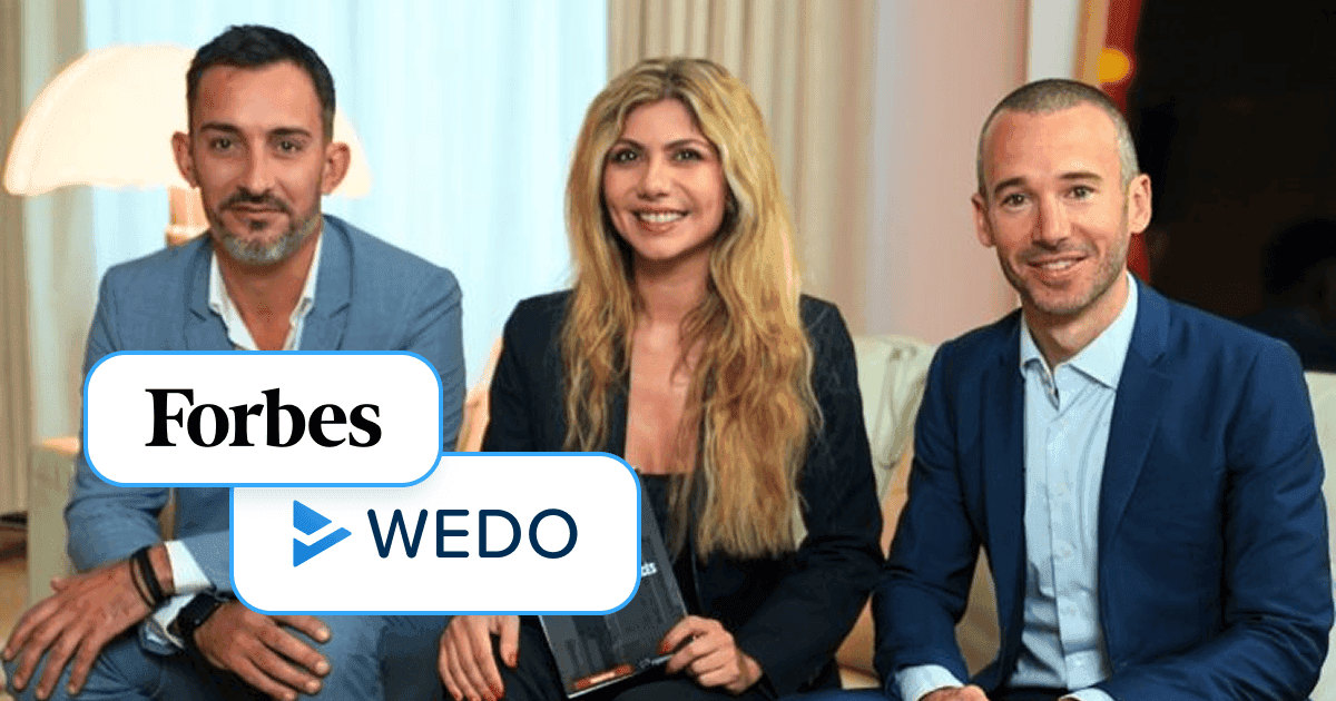 Three business professionals—a woman holding a Forbes magazine flanked by two men—sit on a couch in a well-lit room, each smiling at the camera. Overlaid in the foreground are the “Forbes” logo and the WEDO logo